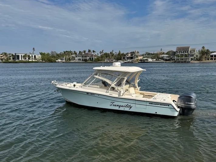 Tranquility Yacht Photos Pics 2021 Grady-White Freedom 285 boat on calm water, coastal homes in background.