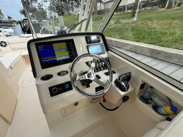 Tranquility Yacht Photos Pics 2021 Grady-White Freedom 285 boat cockpit with steering wheel and navigation controls.