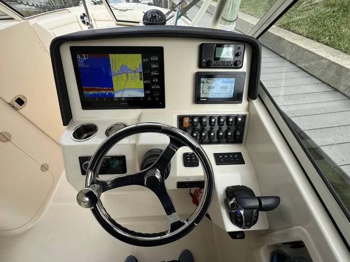 Tranquility Yacht Photos Pics Grady-White Freedom 285 2021 boat dashboard with steering wheel and navigation displays.