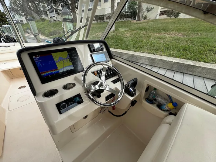 Tranquility Yacht Photos Pics 2021 Grady-White Freedom 285 boat cockpit with modern navigation system and steering wheel.