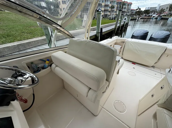 Tranquility Yacht Photos Pics 2021 Grady-White Freedom 285 boat interior with helm seat and waterfront view.