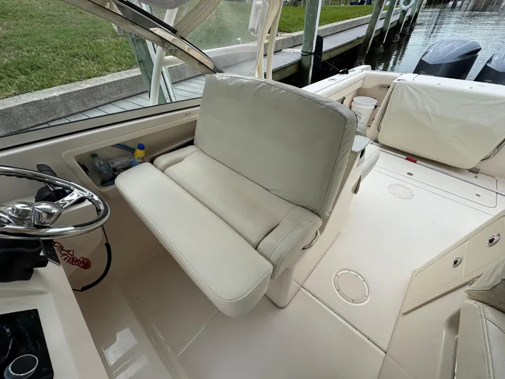 Tranquility Yacht Photos Pics 2021 Grady-White Freedom 285 boat interior with white seating and steering wheel.