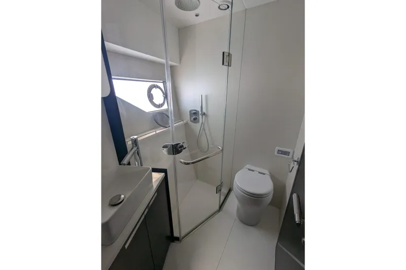  Yacht Photos Pics Luxurious bathroom in 2022 Sunseeker Predator 55 EVO yacht, featuring modern fixtures and glass shower.