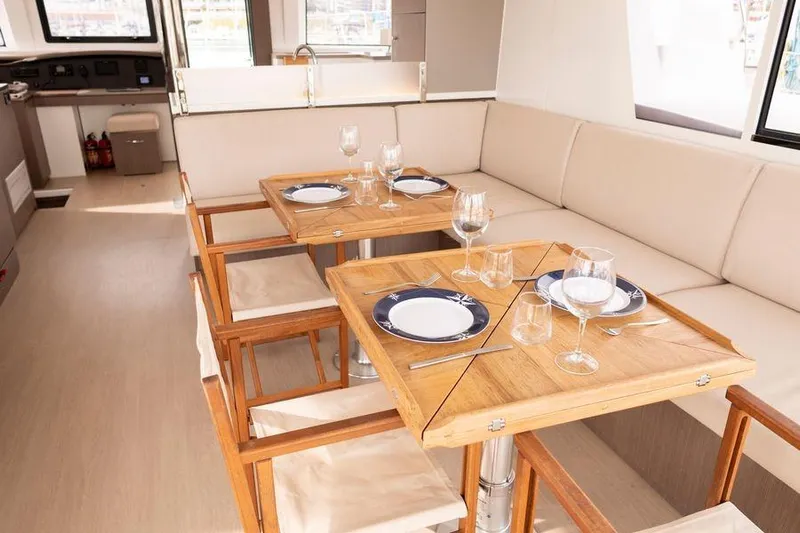 Tatani Yacht Photos Pics Elegant dining area on 2021 Bali 4.8 yacht with wooden tables and cushioned seating.