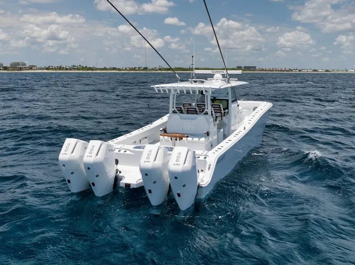 Sycorax Yacht Photos Pics 2024 Freeman 43 CC boat with four engines on open water under a partly cloudy sky.