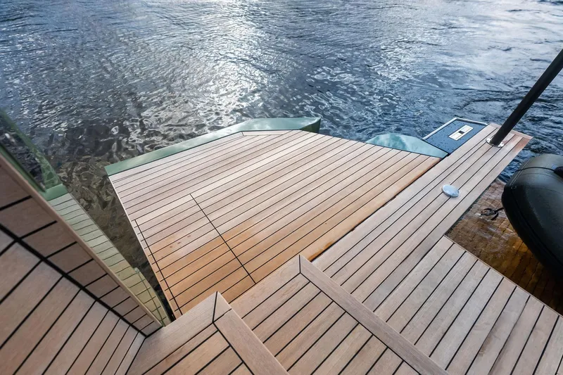 Another World Yacht Photos Pics Wallytender 100 yacht deck, 2025 model, featuring sleek wooden design by the water.
