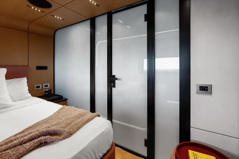 Another World Yacht Photos Pics Luxurious interior of 2025 Wally Wallytender 100 yacht with modern design and cozy bedding.