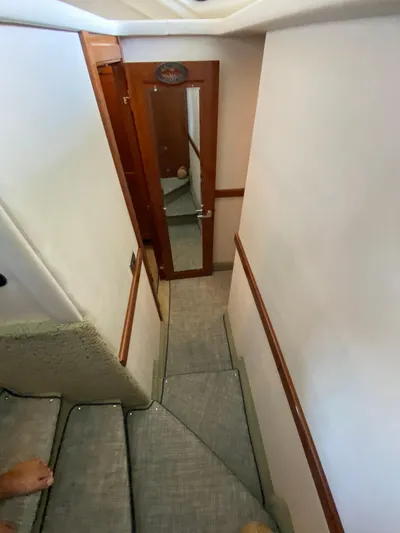 Dream Chaser Yacht Photos Pics Staircase inside 2008 Sea Ray 47 Sedan Bridge yacht with carpeted steps and wooden door.