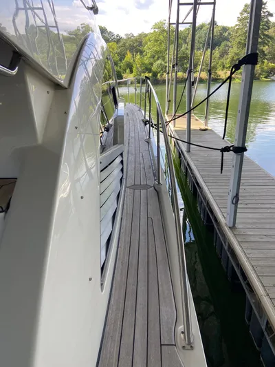 Dream Chaser Yacht Photos Pics 2008 Sea Ray 47 Sedan Bridge yacht docked by a serene lake.
