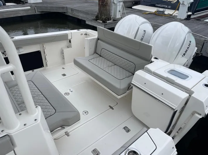  Yacht Photos Pics 2022 Pursuit S 328 Sport boat with Yamaha engines, docked, featuring cushioned seating.