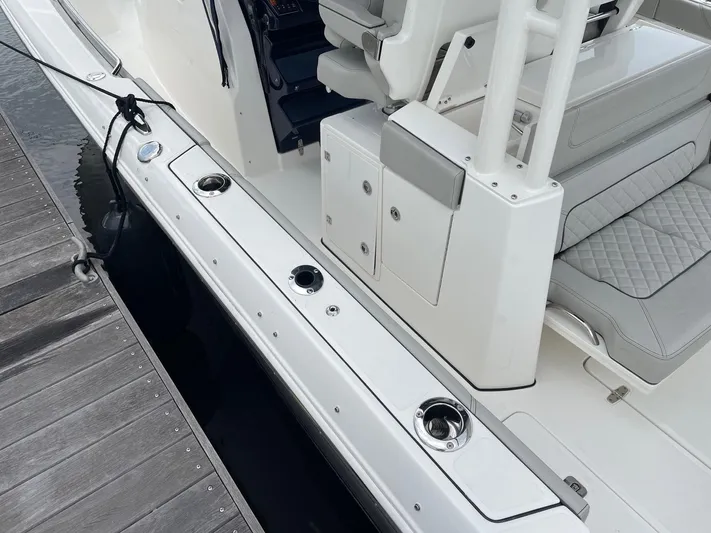  Yacht Photos Pics 2022 Pursuit S 328 Sport boat docked, showcasing seating and rod holders.