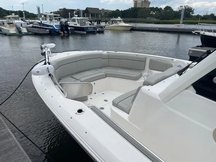  Yacht Photos Pics 2022 Pursuit S 328 Sport boat docked, featuring spacious seating area.