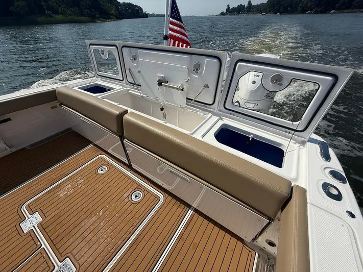  Yacht Photos Pics 2023 Everglades 395 Center Console boat with open storage compartments on a sunny day.