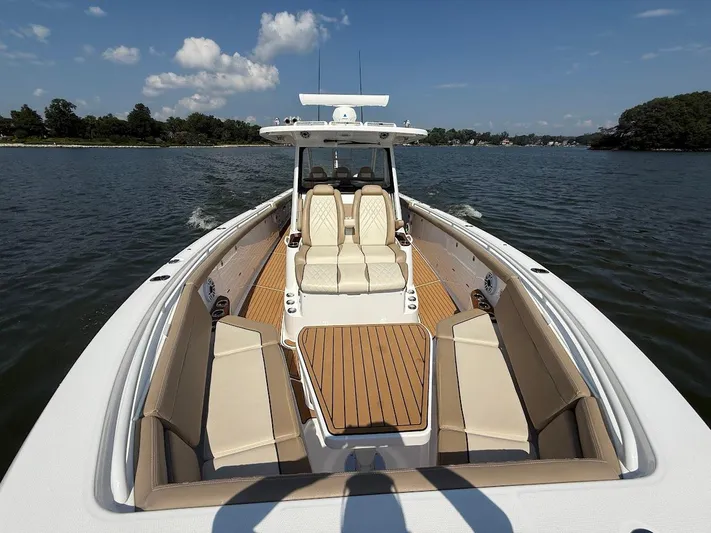  Yacht Photos Pics 2023 Everglades 395 Center Console boat on water, featuring spacious seating and sleek design.