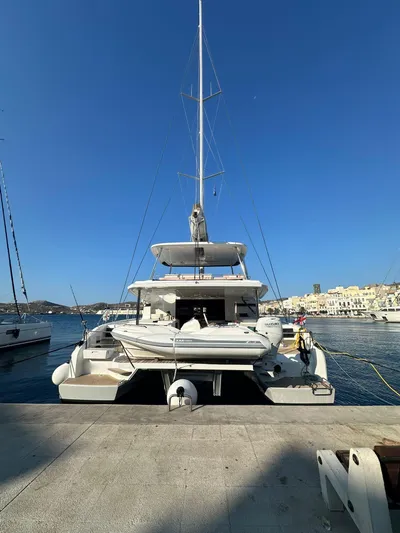  Yacht Photos Pics 2023 Lagoon 55 catamaran docked at a marina under clear blue skies.