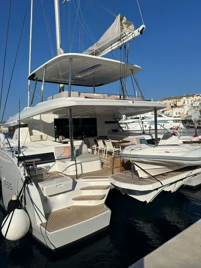  Yacht Photos Pics 2023 Lagoon 55 yacht docked, featuring spacious deck and modern design.