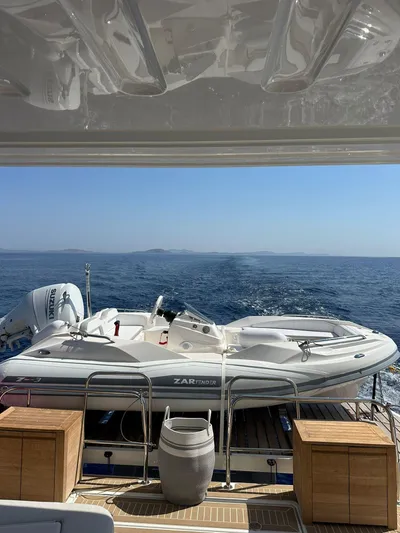  Yacht Photos Pics 2023 Lagoon 55 yacht with a small boat on deck, overlooking the ocean.