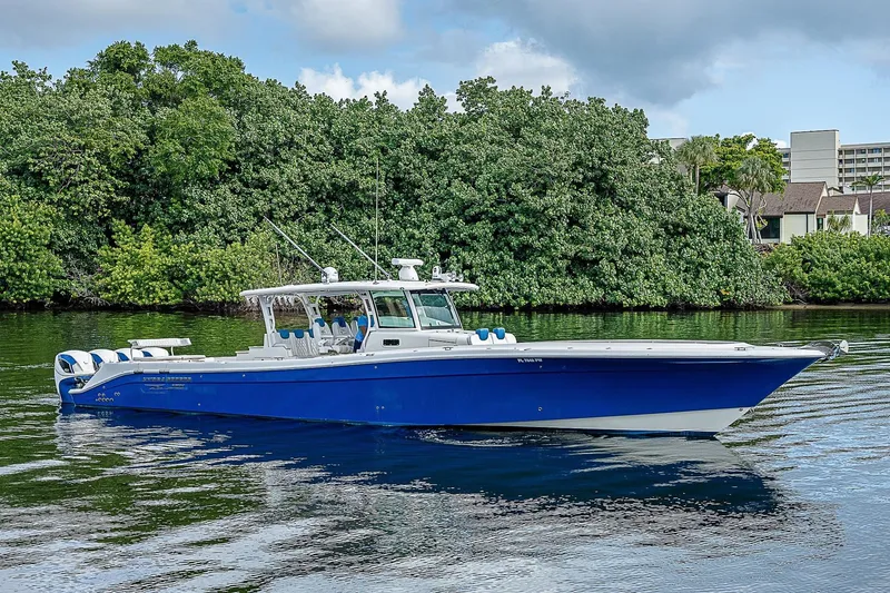  Yacht Photos Pics 2016 HCB 53 Sueños boat on calm water, surrounded by lush greenery.