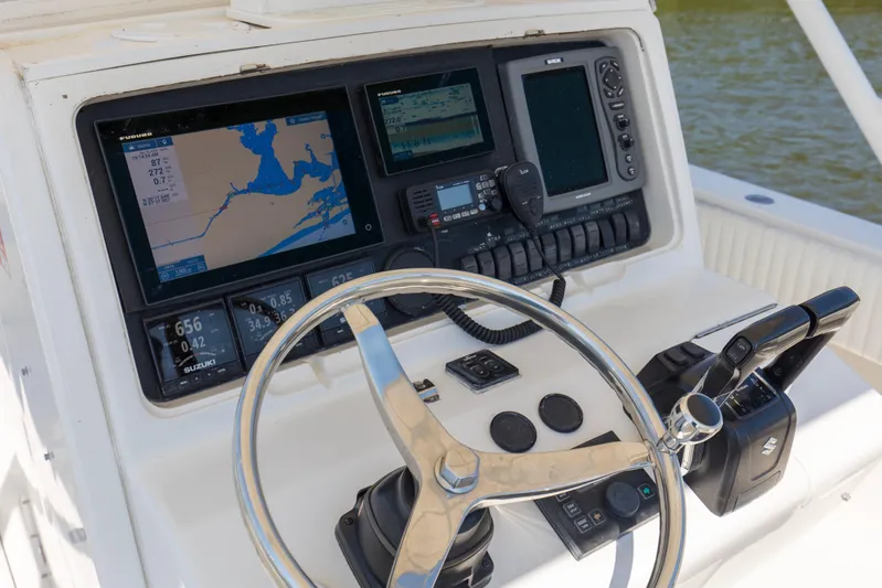 Miss Millie II Yacht Photos Pics Control panel of 2003 Jupiter 31 Open boat with navigation screens and steering wheel.