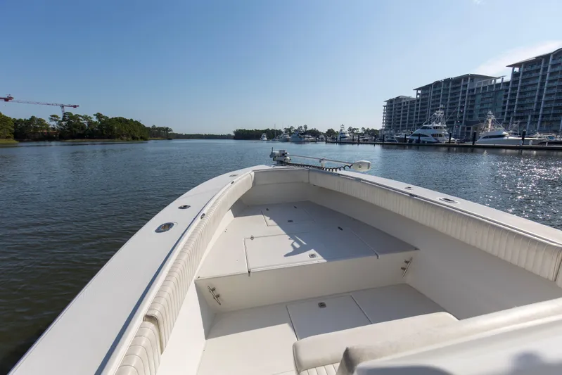 Miss Millie II Yacht Photos Pics 2003 Jupiter 31 Open boat cruising in a marina with modern buildings in the background.