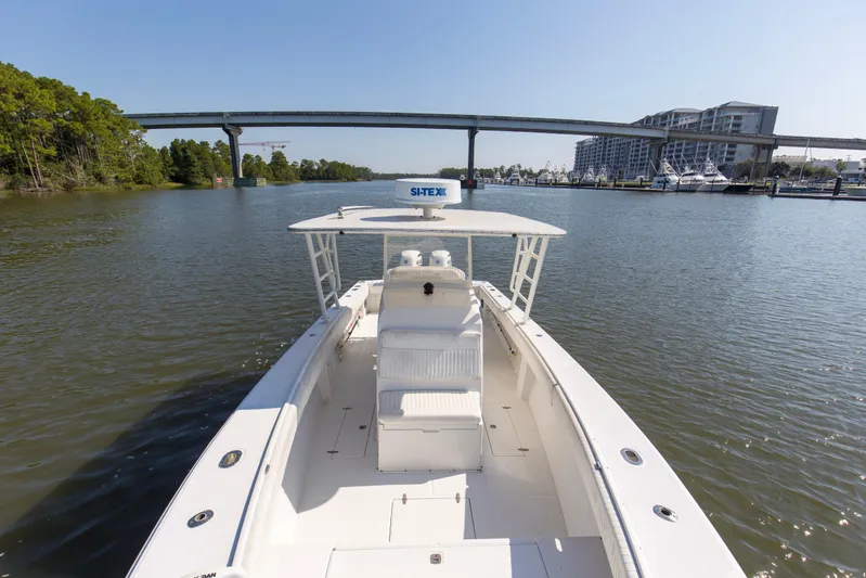 Miss Millie II Yacht Photos Pics 2003 Jupiter 31 Open boat cruising on a calm river near a bridge and buildings.