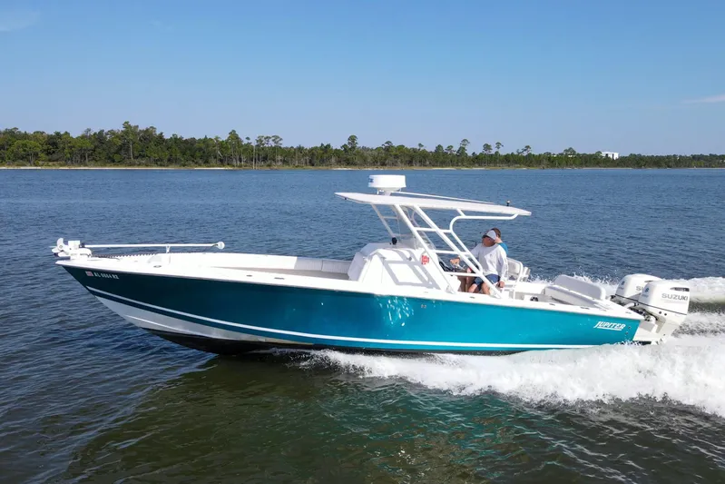 Miss Millie II Yacht Photos Pics 2003 Jupiter 31 Open boat cruising on a calm lake with lush green shoreline.