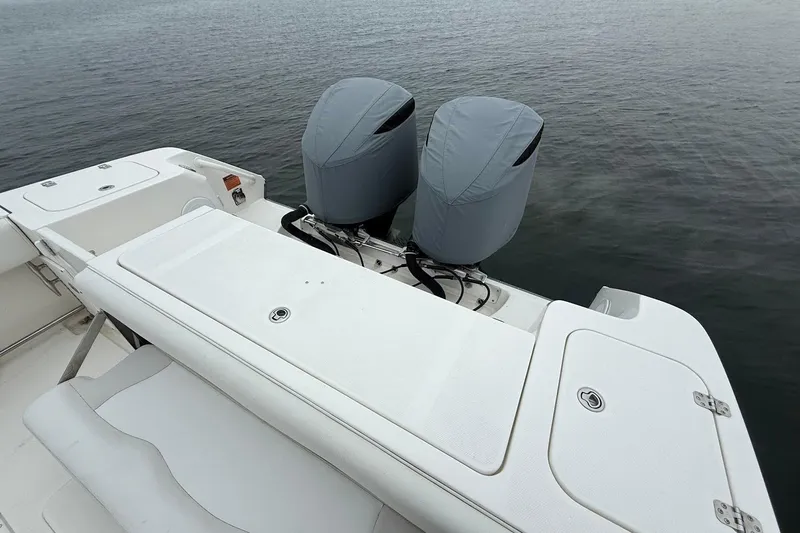  Yacht Photos Pics 2013 Edgewater 318CC boat with covered dual outboard motors on calm water.