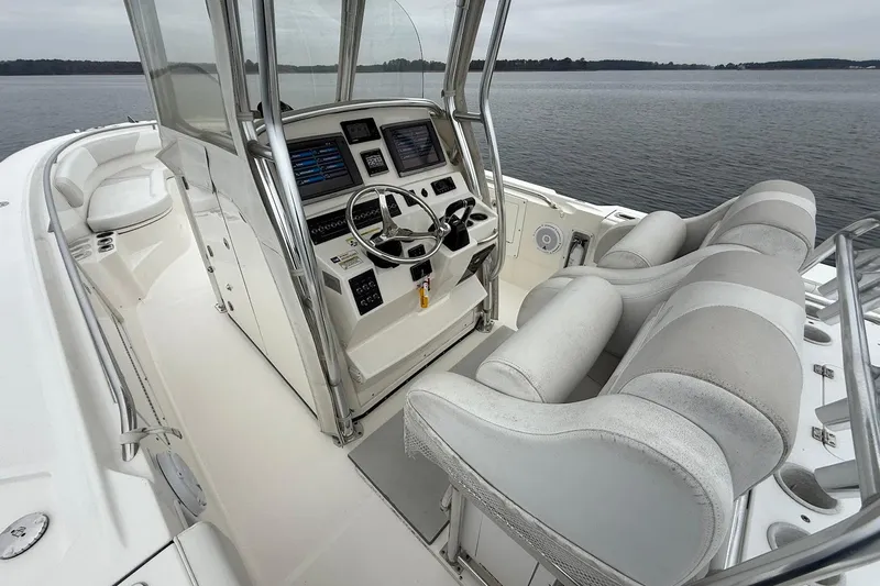  Yacht Photos Pics 2013 Edgewater 318CC boat interior with dual seats and control panel on calm water.