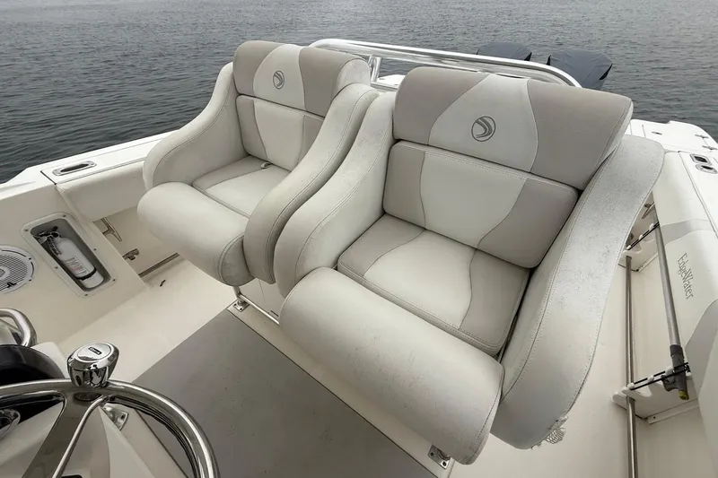  Yacht Photos Pics 2013 Edgewater 318CC boat with plush dual seats, steering wheel, and ocean backdrop.