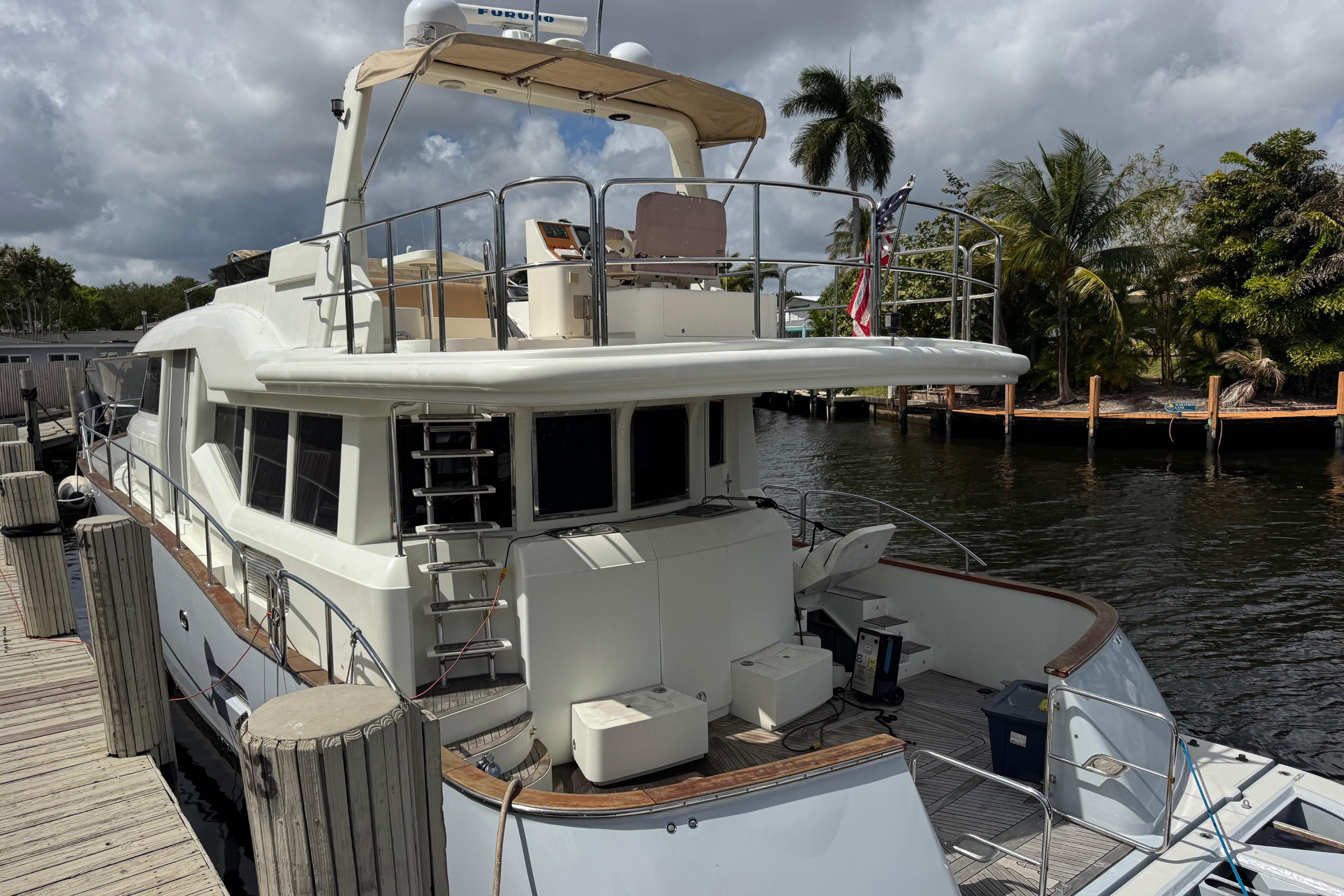 2003 Custom Sea Star Pilot House yacht docked by palm trees and waterway.