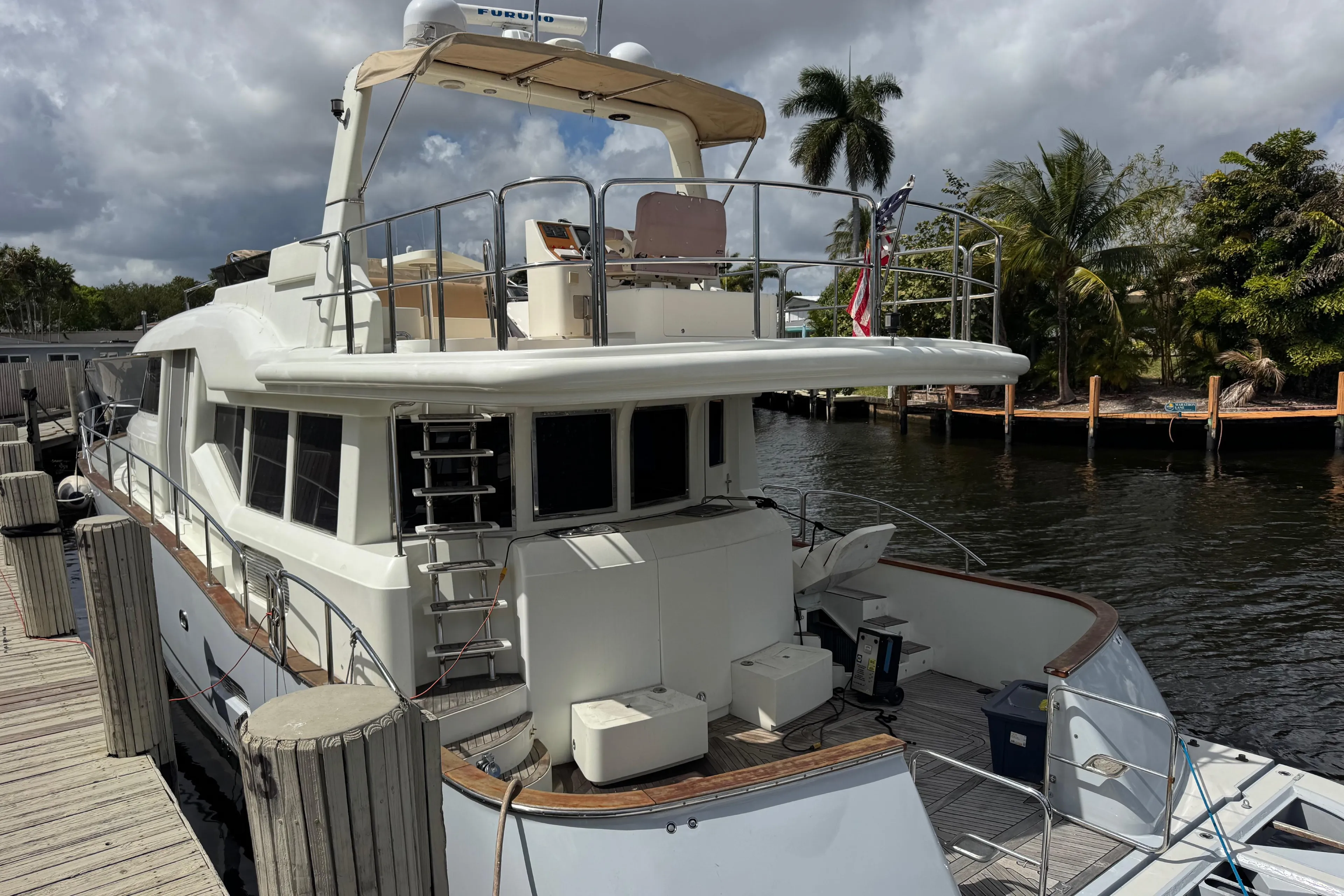2003 Custom Sea Star Pilot House yacht docked by palm trees and waterway.