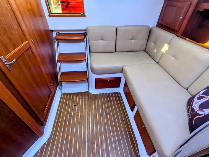 Grand Cove Yacht Photos Pics 2014 Back Cove 34 interior with beige seating, wooden flooring, and storage cabinets.