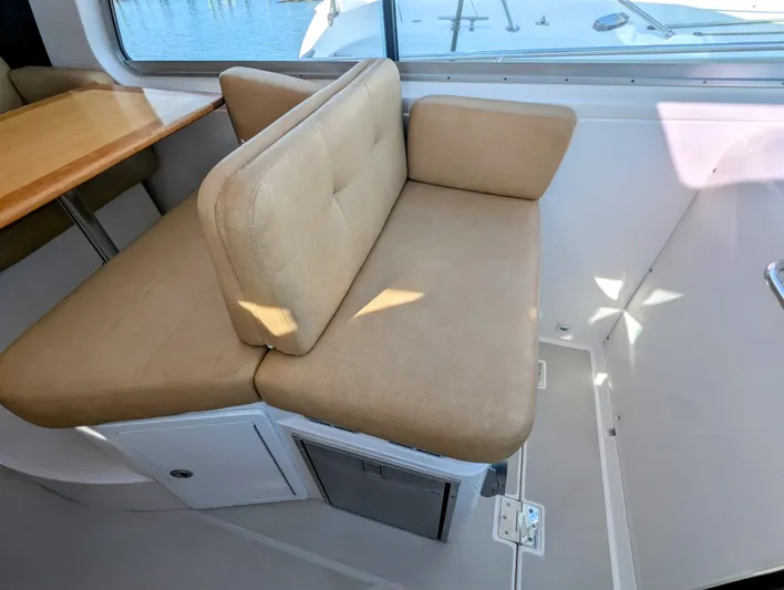 Grand Cove Yacht Photos Pics 2014 Back Cove 34 interior with beige seating and wooden table, showcasing modern design.