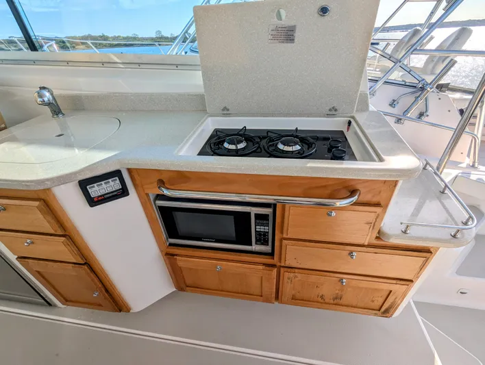 Grand Cove Yacht Photos Pics 2014 Back Cove 34 yacht kitchen with stove, microwave, and wooden cabinets.