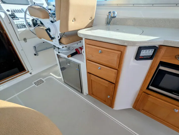 Grand Cove Yacht Photos Pics Interior of 2014 Back Cove 34 boat with helm seat, sink, and wooden cabinetry.