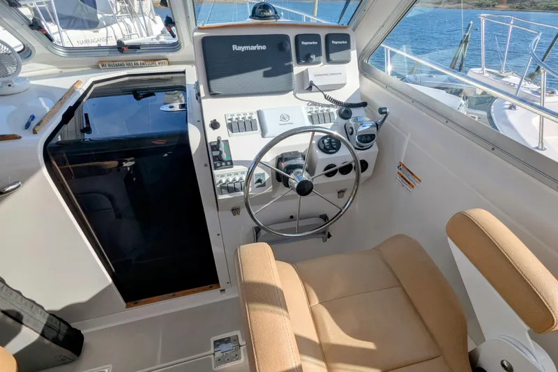 Grand Cove Yacht Photos Pics 2014 Back Cove 34 helm with steering wheel, navigation controls, and beige seating.
