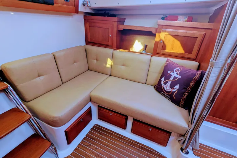 Grand Cove Yacht Photos Pics 2014 Back Cove 34 interior with beige L-shaped seating and nautical-themed decor.