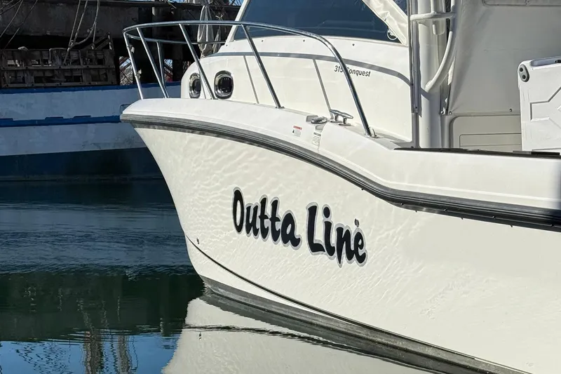 Outta Line Yacht Photos Pics 2017 Boston Whaler 315 Conquest boat named "Outta Line" docked in calm water.
