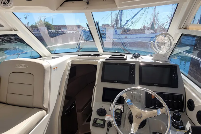 Outta Line Yacht Photos Pics Interior view of 2017 Boston Whaler 315 Conquest boat cockpit with navigation equipment.