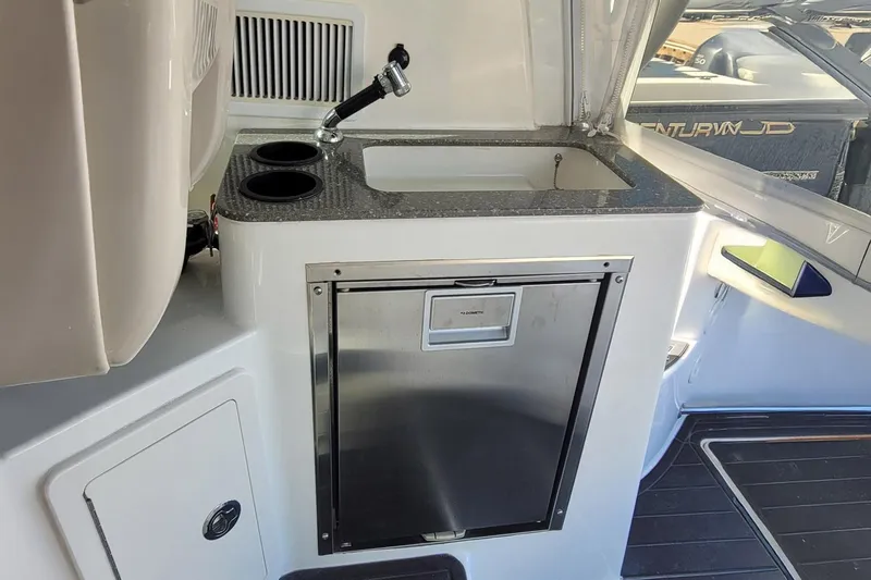 Outta Line Yacht Photos Pics 2017 Boston Whaler 315 Conquest boat interior with sink and mini fridge.