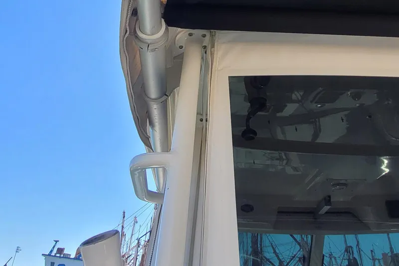 Outta Line Yacht Photos Pics Close-up of 2017 Boston Whaler 315 Conquest boat structure against clear blue sky.