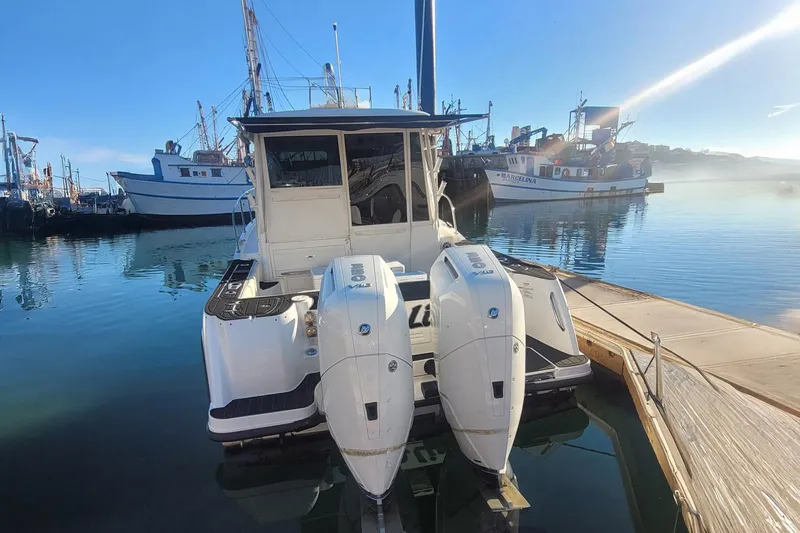 Outta Line Yacht Photos Pics 2017 Boston Whaler 315 Conquest docked with twin outboard engines, in a marina setting.