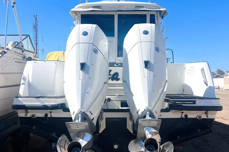 Outta Line Yacht Photos Pics 2017 Boston Whaler 315 Conquest with dual outboard engines, docked under clear blue sky.