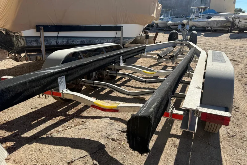 Outta Line Yacht Photos Pics Boat trailer for 2017 Boston Whaler 315 Conquest, parked on sandy ground.