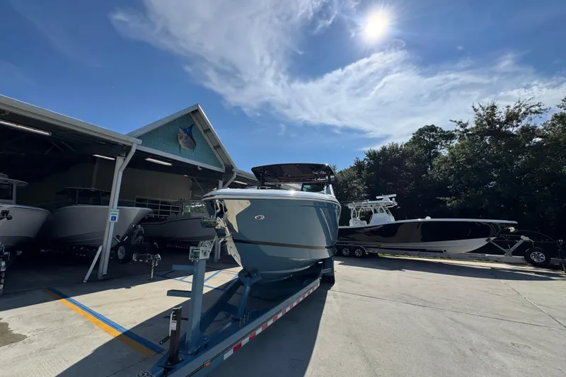  Yacht Photos Pics 2024 Cobalt R33 boat on trailer under sunny sky at marina.