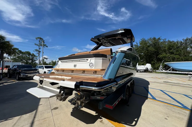  Yacht Photos Pics 2024 Cobalt R33 boat on trailer, showcasing sleek design and spacious deck under clear blue sky.