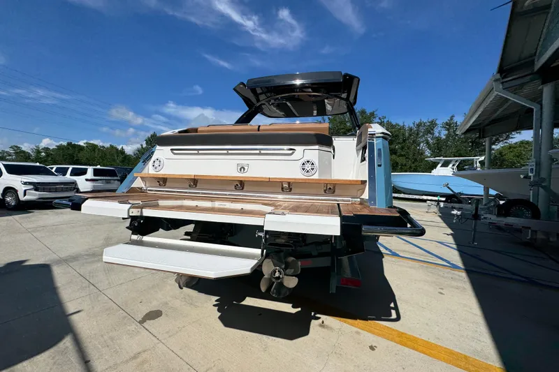  Yacht Photos Pics 2024 Cobalt R33 boat rear view, showcasing swim platform and sleek design in a marina setting.