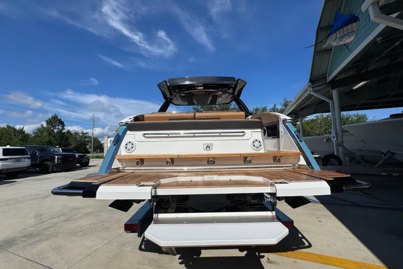  Yacht Photos Pics 2024 Cobalt R33 boat rear view with teak swim platform under clear blue sky.