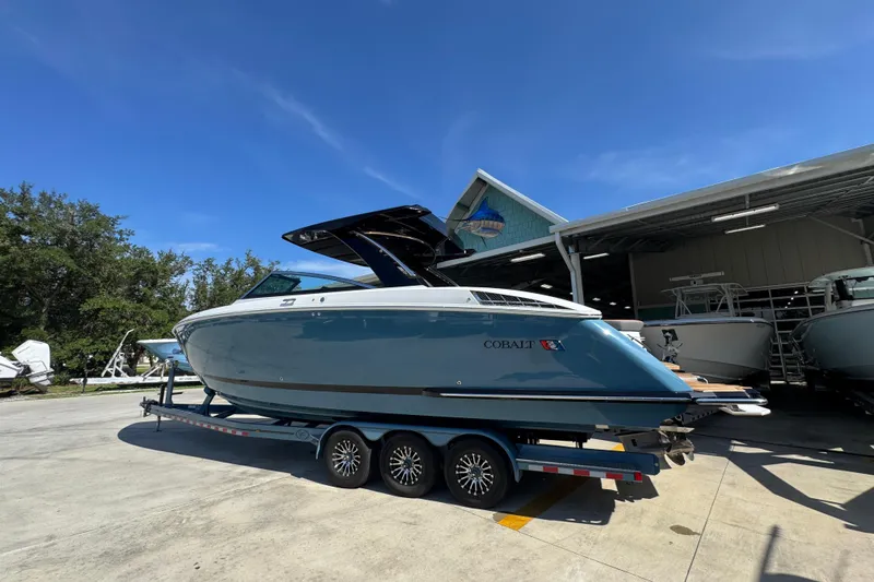  Yacht Photos Pics 2024 Cobalt R33 boat on trailer under clear blue sky at marina.