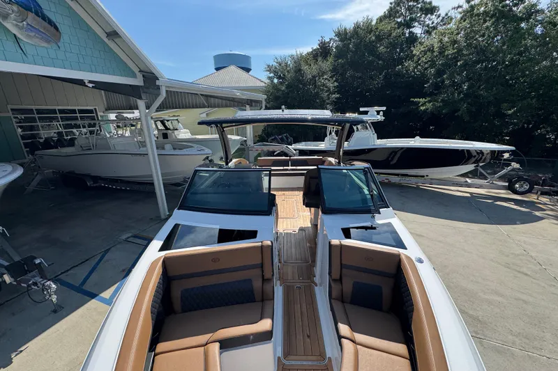  Yacht Photos Pics 2024 Cobalt R33 boat with sleek design, docked at a marina, surrounded by other boats.